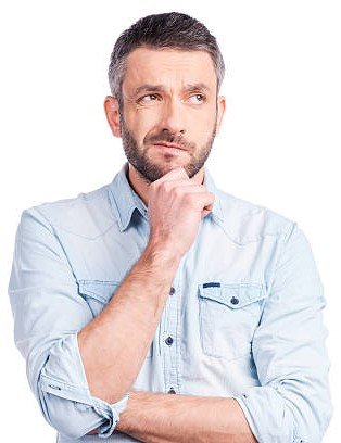 Frustrated young man in casual wear holding hand on chin and looking away while standing isolated on white background
